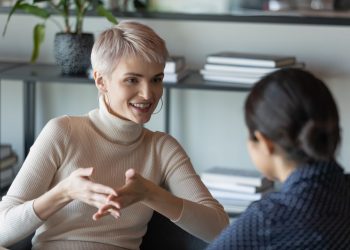 Confident short-haired businesswoman talk with client during formal meeting in office. HR manager applicant interaction at job interview communication. Two diverse mates discuss common project concept